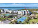 Aerial view of multiple condominiums with ocean view and tennis courts at 9203 Griggs Rd # A204, Englewood, FL 34224