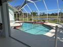 A sparkling screened in-ground pool, perfect for relaxation, overlooking a tranquil canal at 108 Fairway Rd, Rotonda West, FL 33947