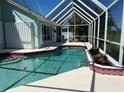 Sparkling pool within a screened enclosure, featuring a waterfall feature and ample deck space for relaxation and entertaining at 108 Fairway Rd, Rotonda West, FL 33947