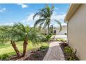 Beautiful home showcasing palm trees, verdant grass, and a charming brick walkway at 11417 Okaloosa Dr, Venice, FL 34293