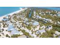 An aerial view of a charming coastal community with a beautiful beach nearby at 14 Palm Dr, Placida, FL 33946