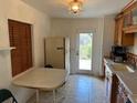 Practical kitchen with tiled floors, simple lighting, and a clear view to the outside at 1417 Terry Ave, Punta Gorda, FL 33980