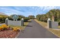 Community sign entrance, showcasing a tree-lined driveway and manicured landscaping at 14281 Palm Ter, Port Charlotte, FL 33953