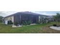 Picture of a backyard featuring a screened patio and well maintained lawn at 171 Caddy Rd, Rotonda West, FL 33947