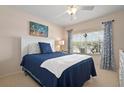 Cozy bedroom with a large window, ceiling fan, and stylish decor at 202 Silver Lake Dr # 203, Venice, FL 34292