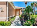 Charming front entrance with manicured bushes and flowering plants leading to the front door of the home at 2625 Wax Myrtle, Port Charlotte, FL 33953