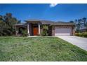 Charming single-story home featuring a stone facade and well-manicured lawn at 3284 Newmark St, North Port, FL 34291