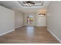 Open living room with wood-look flooring, arched windows, and decorative ceilings at 3284 Newmark St, North Port, FL 34291