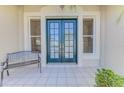 Covered front porch with double door entrance and tiled flooring at 3574 Pennyroyal Rd, Port Charlotte, FL 33953