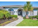 Close up of the front entrance of the home, with arched windows and a brick path at 3615 Pennyroyal Rd, Port Charlotte, FL 33953