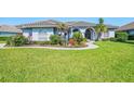 Charming single-story home with arched windows, complemented by vibrant landscaping at 3615 Pennyroyal Rd, Port Charlotte, FL 33953