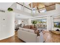 Bright, open-concept living room boasts hardwood floors, high ceilings, and seamless indoor-outdoor living at 38 Seawatch Lake Dr, Boca Grande, FL 33921