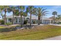 Attractive home featuring mature palm trees, meticulously landscaped front yard, and well-maintained lawn at 4 Sportsman Ln, Rotonda West, FL 33947