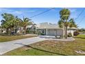 Charming home featuring a three-car garage, and a beautifully landscaped front yard with mature palm trees at 4 Sportsman Ln, Rotonda West, FL 33947