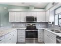 Stylish kitchen featuring stainless steel appliances, granite countertops, and white cabinets at 4260 Placida Rd # 8D, Englewood, FL 34224
