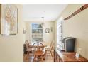 Bright dining area with round wooden table and views of the outdoors at 6610 Gasparilla Pines Blvd # 113, Englewood, FL 34224