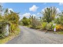 This home's driveway is long and private, flanked by lush greenery and flowering shrubs at 730 Buckskin Ct, Englewood, FL 34223