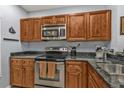 Stainless steel appliances accent the wood cabinetry and dark granite countertops at 8409 Placida Rd # 305, Placida, FL 33946