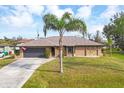 Charming home with stone accents, fresh landscaping, and inviting driveway leading to an attached garage at 9260 Saint Catherine Ave, Englewood, FL 34224