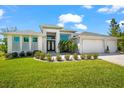 Well-kept lawn and landscaping accentuates the front of this contemporary home with a three-car garage at 10491 Sarasota Rd, Port Charlotte, FL 33981