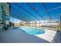 Enclosed pool and patio with views of landscaping, waterfront canal, and boat docks at 1052 Newton St, Englewood, FL 34224