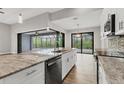 Open kitchen with an island, stainless appliances, and view of screened pool and lanai through sliding doors at 10782 Kearsarge Cir, Port Charlotte, FL 33981
