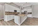 Modern kitchen featuring white cabinets, granite countertops, and stainless steel appliances at 10782 Kearsarge Cir, Port Charlotte, FL 33981