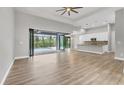 Open-concept living area with wood-look floors and sliding glass doors to a screened lanai and pool at 10782 Kearsarge Cir, Port Charlotte, FL 33981