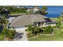 Aerial view of a home near the water with solar panels, a well manicured lawn, and lush landscaping at 12432 Nova Ave, Port Charlotte, FL 33981