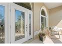 A beautiful, decorative glass front door is surrounded by a manicured lawn and sitting area at 12432 Nova Ave, Port Charlotte, FL 33981