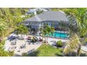An aerial view displays a home with a screened-in pool area, set in a neighborhood with lush greenery at 13379 Journal Ln, Port Charlotte, FL 33981