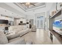 Spacious living room flows to kitchen, featuring recessed lights, ceiling fan and tile floors at 13379 Journal Ln, Port Charlotte, FL 33981