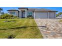 Charming home showcasing a paved driveway and well-maintained lawn, blending comfort and style at 14286 Fort Worth Cir, Port Charlotte, FL 33981