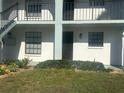 Close-up of unit 201 with a small, manicured yard, windows, and a dark brown front door at 150 Englewood Isles Pkwy # 201, Englewood, FL 34223