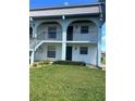Two story condo building with a lush green lawn and lovely archways on the upper level at 150 Englewood Isles Pkwy # 201, Englewood, FL 34223