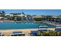 Community swimming pool with lounge chairs and mature landscaping and people enjoying the water at 150 Englewood Isles Pkwy # 201, Englewood, FL 34223