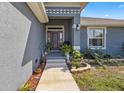 Elegant front entryway with decorative plants and a modern paint scheme at 15251 Appleton Blvd, Port Charlotte, FL 33981