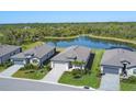 Aerial view of homes with meticulously maintained lawns surrounding a serene pond and wooded preserve at 1758 Saddlewood Cir, Port Charlotte, FL 33953