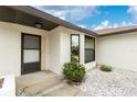 Inviting front entrance with a neutral color scheme, complemented by landscaping and well kept concrete at 20 Bunker Way, Rotonda West, FL 33947