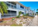 Building exterior with green space, featuring a screened-in balcony and tropical plants at 200 Rotonda W Blvd # A2, Rotonda West, FL 33947