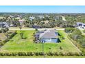 A backyard view of a single-Gathering home featuring a well-manicured lawn and a screened-in patio at 213 Sunset Rd, Rotonda West, FL 33947