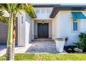 The front entrance to a single-Gathering home with a well-manicured lawn and landscaping at 213 Sunset Rd, Rotonda West, FL 33947