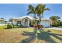Charming single-story home with a metal roof, lush landscaping, and a welcoming front porch at 25 Medalist Ter, Rotonda West, FL 33947