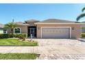 Welcoming single-Gathering home boasting a two-car garage, paver driveway, and well-maintained lawn with lush landscaping at 284 Talquin Ct, Englewood, FL 34223