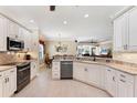 Modern kitchen with white cabinets, granite countertops, stainless steel appliances, and an open view to the dining area at 284 Talquin Ct, Englewood, FL 34223