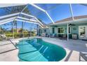Inviting screened-in pool area with outdoor seating and dining space at 5 Pine Valley Rd, Rotonda West, FL 33947