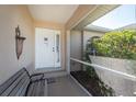 Inviting front porch with a comfortable bench and a decorative front door with glass panels at 51 Mark Twain Ln, Rotonda West, FL 33947