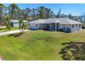 A well-maintained home with a lush green lawn, a detached garage, and a beautifully landscaped yard at 5258 Grassland Ter, Port Charlotte, FL 33981