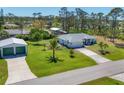 Charming single-Gathering home featuring a well-manicured lawn, mature palm trees, and a detached garage at 5258 Grassland Ter, Port Charlotte, FL 33981