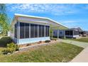 A side view of this lovely home featuring an enclosed screen porch and colorful, well-maintained landscaping at 5619 Bayshore Rd # 240, Palmetto, FL 34221